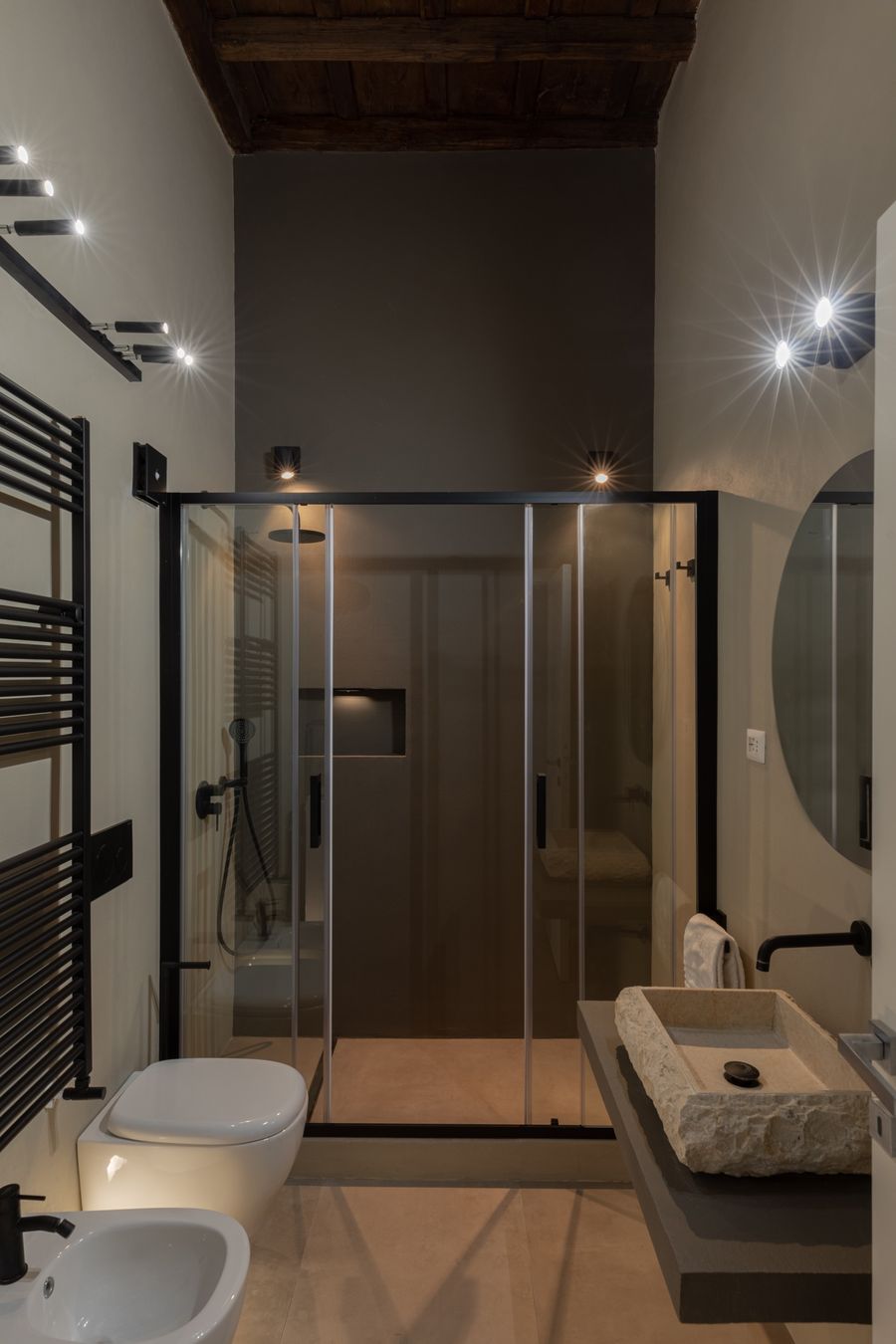 Bathroom with a glass shower, exposed beams and spotlights