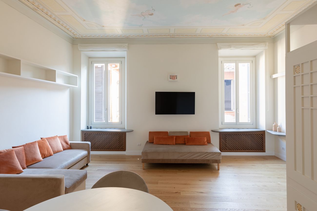 Living room with two windows, a painted ceiling and oak parquet